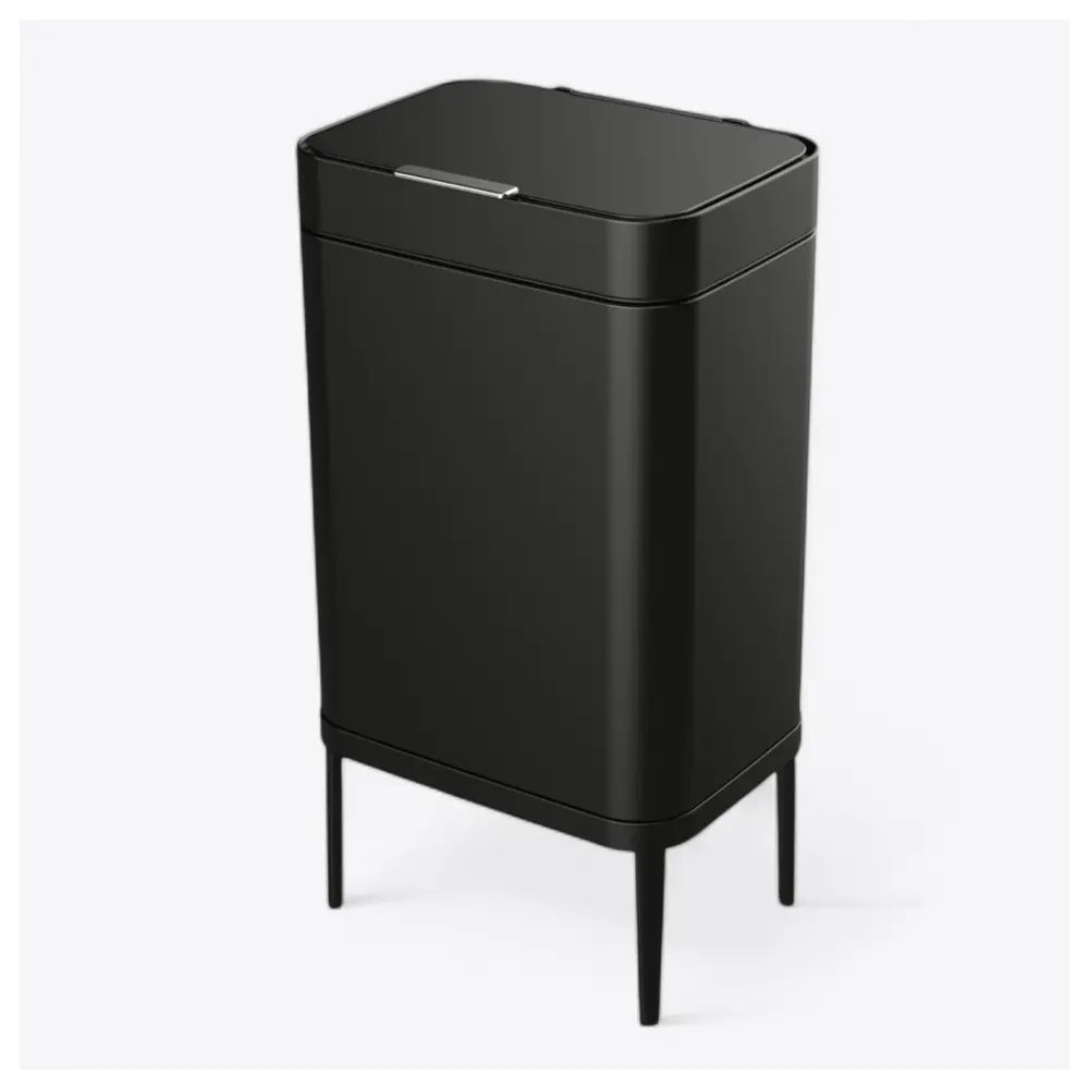 ה-Lano PressOpen – פח אשפה נפתח בלחיצה בנפח 60 ליטר הוא פח אשפה מטבח שחור ומסוגנן, בעל צורה מלבנית, קצוות מעוגלים, מכסה וארבע רגליים דקיקות, המוצג על רקע לבן חלק.