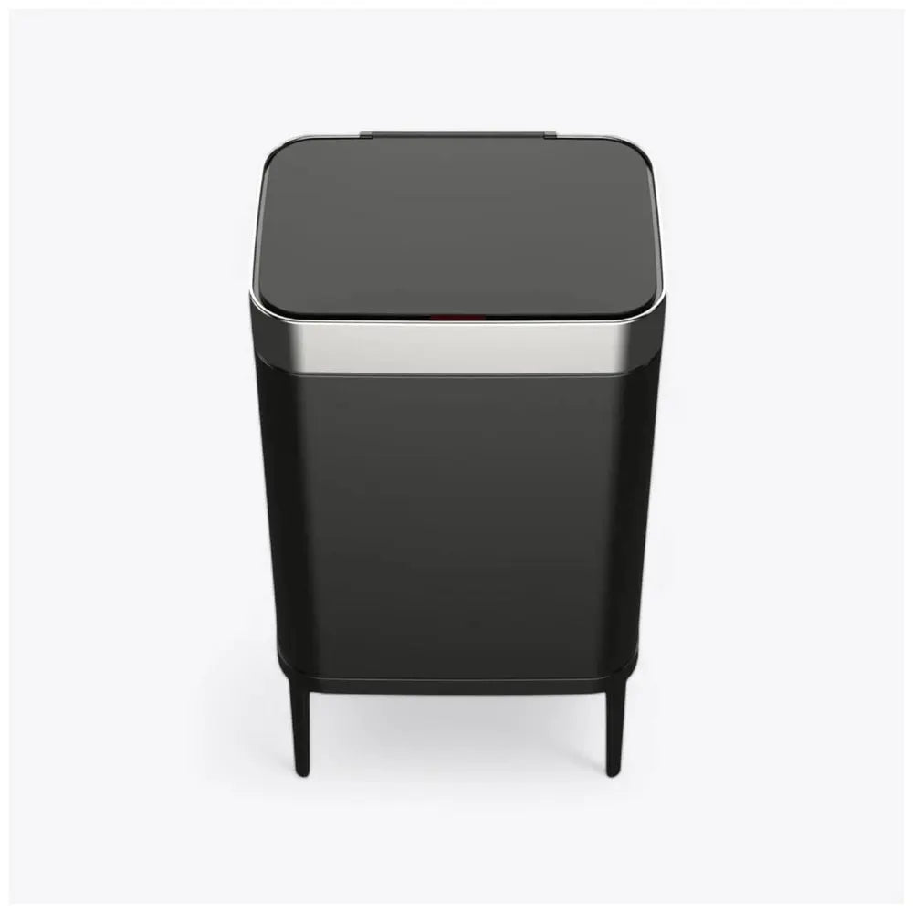הפח אשפה אוטומטי 60 ליטר עם חיישן עליון מבית משלוח חינם הוא פח יוקרתי שחור בצורת מלבן עם מכסה שטוח וגימור מתכתי, ניצב על ארבע רגליים דקות ברקע לבן.
